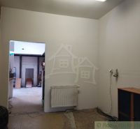 Innenraum eines Einfamilienhauses mit weißen Wänden, Heizkörper und offenen Türen.