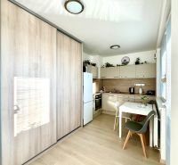 Küchenecke mit Holzboden und Einbauschrank in einer Einzimmerwohnung.