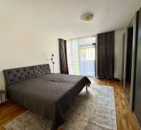 Schlafzimmer in einer 4-Zimmer-Wohnung mit Holzboden, großem Bett und Kleiderschrank.
