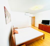 Helles Schlafzimmer in einer 4-Zimmer-Wohnung mit Holzboden, Bett und Kommode.
