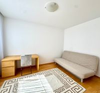 Ein Zimmer mit einem hellen Sofa, einem Schreibtisch und einem Boden mit Holzdekor in einer 4-Zimmer-Wohnung.
