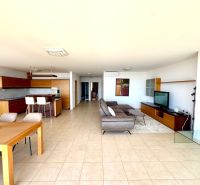 Geräumiges Wohnzimmer in einer 4-Zimmer-Wohnung mit Küche, Fliesen und bequemer Sitzgelegenheit.