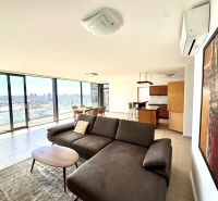Geräumiger Wohnbereich in einer 4-Zimmer-Wohnung mit großen Fenstern und Blick auf die Stadt.