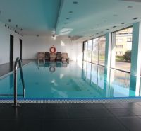 Innenpool mit Liegestühlen in einer 4-Zimmer-Wohnung.
