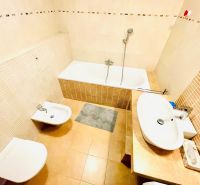 Badezimmer in einer 4-Zimmer-Wohnung mit Badewanne, Bidet und Waschbecken in hellen Farbtönen.