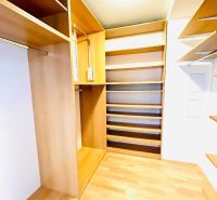 Ein Kleiderschrank mit Regalen und einem Boden in Holzdekor in einer 4-Zimmer-Wohnung.