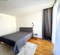 Schlafzimmer in einer 4-Zimmer-Wohnung mit Bett, Vorhängen und Boden in Holzoptik.