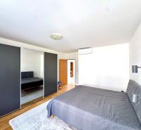 Schlafzimmer in einer 4-Zimmer-Wohnung mit einem großen Kleiderschrank und einem Boden in Holzoptik.
