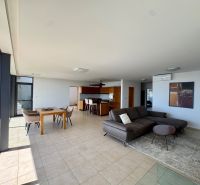 Geräumiges Wohnzimmer in einer 4-Zimmer-Wohnung mit großen Fenstern, Sofa und Esstisch.