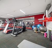 Fitnesscenter mit Laufbändern und Trainingsgeräten in Geschäftsräumen.