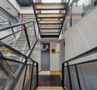 Ein Flur mit einer Metalltreppe und einem Gittergeländer in Geschäftsräumen.