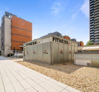 Exterieur Bratislava - Nivy, Trenčianska: Fitnesscenter umgeben von modernen Gebäuden und befestigten Flächen.