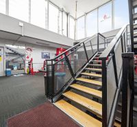 Innenraum von Geschäftsräumen mit Metalltreppe und Fitnessgeräten.