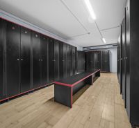 Schwarze Boxen, Bänke mit kontrastierendem Design, Boden mit Holzdekor in Geschäftsräumen.