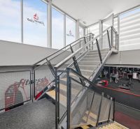 Stahltreppe in zweistöckigen Geschäftsräumen mit Fitnessgeräten.