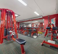 Fitnesscenter mit roten Trainingsgeräten und Hanteln, Geschäftsräume.