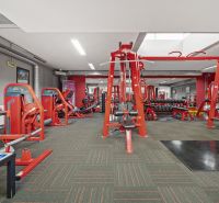 Fitnessstudio mit Kraftgeräten und Hanteln in Geschäftsräumen.