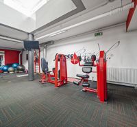 Fitnesscenter mit Kraftgeräten, Laufband und Gymnastikbällen, Geschäftsräume.