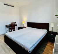 Schlafzimmer mit großem Bett, Schreibtisch und Holzboden in einer 3-Zimmer-Wohnung.