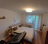 Schlafzimmer in einer 2-Zimmer-Wohnung mit Holzboden und Trainingsgerät.
