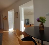 Innenraum einer 2-Zimmer-Wohnung mit Holzboden und einer Vase auf dem Tisch.