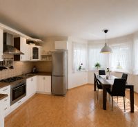 Küche in einem Einfamilienhaus mit weißen Schränken und Esstisch.