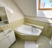 Badezimmer in einem Einfamilienhaus mit Dachfenster und Eckbadewanne.