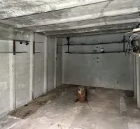 Leerer Betonraum mit Rohren und Beleuchtung, Garageninnenraum.