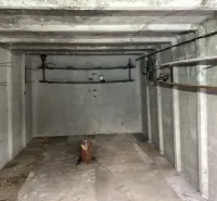 Leerer Betoninnenraum von Garagen mit Regalen und Beleuchtung.