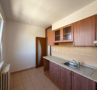 Küche in einer 2-Zimmer-Wohnung mit Keramikfliesen und Holzschränken.