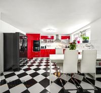 Küche mit schwarz-weißem Boden und roten Schränken in einem Einfamilienhaus.