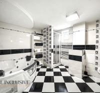 Schwarz-weißes Badezimmer mit Badewanne und Dusche in einem Einfamilienhaus.