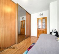 Ein Schlafzimmer in einem Einfamilienhaus mit einem Holzboden und einem großen Schrank mit Spiegel.