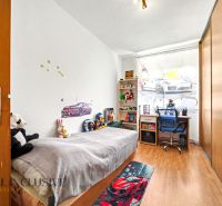 Kinderzimmer in einem Einfamilienhaus mit Spielzeug, Bett und Boden in Holzoptik.