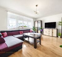 Wohnzimmer in einem Einfamilienhaus mit Ecksofa und Boden in Holzoptik.