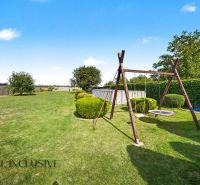 Der Garten des Einfamilienhauses in Vojtechovce in Nový Život mit einer Schaukel und einem Pool.