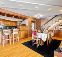Innenraum eines Einfamilienhauses mit Küche, Esstisch und Boden mit Holzdekor.