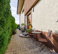 Ein Einfamilienhaus in der Majerská-Straße in Nová Dedinka mit einem Außenbereich zum Sitzen und einer Hecke.
