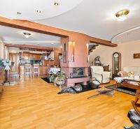 Wohnzimmer in einem Einfamilienhaus mit Kamin und Boden in Holzoptik.