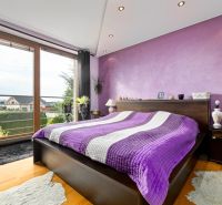 Stilvolles Schlafzimmer mit lila Wand und Aussicht, Boden mit Holzdekor.