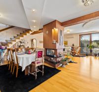 Einfamilienhaus mit Esstisch, Kamin, Holztreppe und Boden mit Holzdekor.