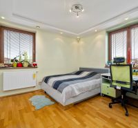 Kinderzimmer in einem Einfamilienhaus mit Bett, Schreibtisch und Boden in Holzoptik.