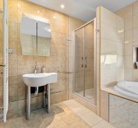Badezimmer mit Badewanne, Dusche und Waschbecken in einem Einfamilienhaus.