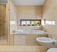 Badezimmer im Einfamilienhaus mit Badewanne, Dusche und Bidet.