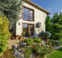 Ein Einfamilienhaus in der Majerská-Straße in Nová Dedinka mit einem bunten Garten und einer Terrasse.