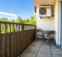 Balkon einer 2-Zimmer-Wohnung mit Blick ins Grüne und Sitzmöbeln.