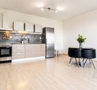 Küche in einer 2-Zimmer-Wohnung mit Holzboden und Esstisch.