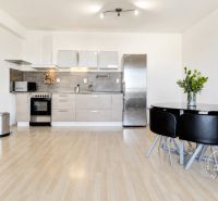 Küche in einer 2-Zimmer-Wohnung mit Holzboden und Esstisch.