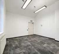 Büros mit Teppichboden und hängenden Leuchten in neutralen Farben.