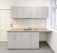 Graue Küchenzeile mit Holzarbeitsplatte im Büro.